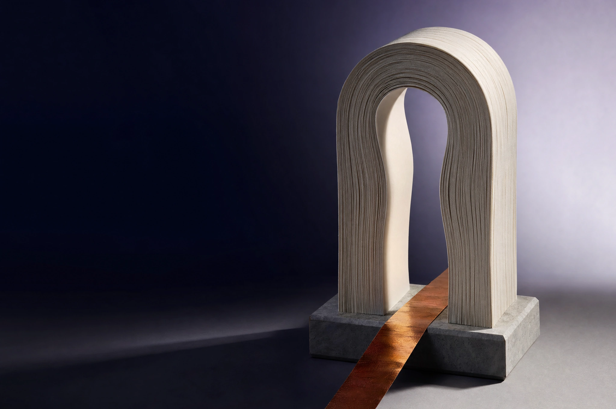 An arch formed from layered ivory paper with a copper ribbon passing through it